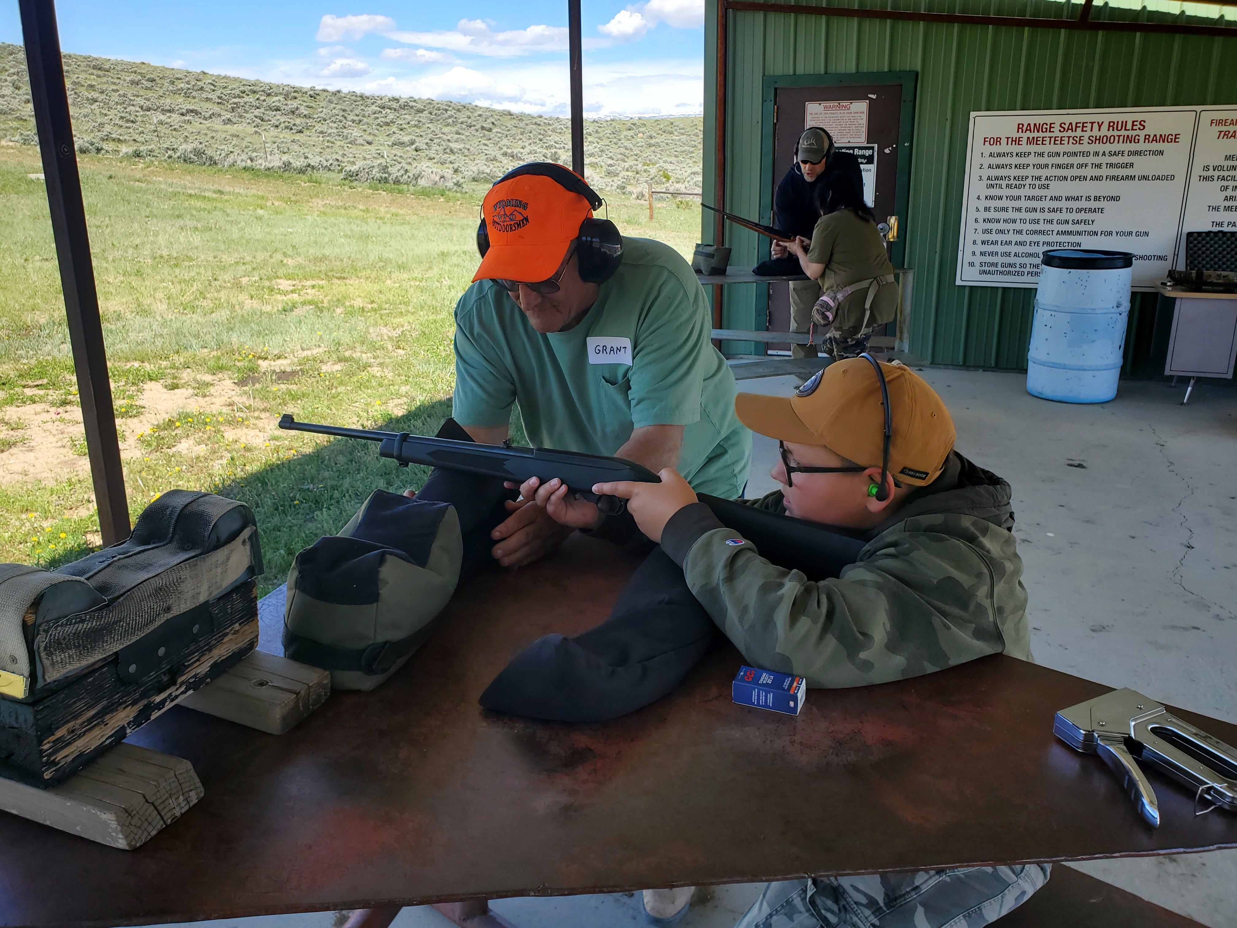 A mentor coaches young hunter on marksmanship during a range day event in 2022. 