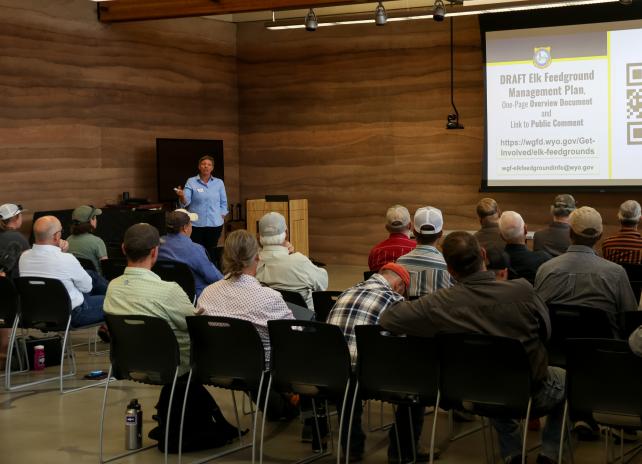 An audience engages with a speaker at a Game and Fish public meeting about the Draft Elk Feedground Management Plan.