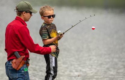 Child fishing with game warden
