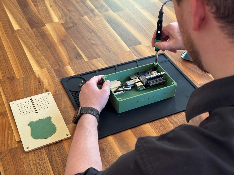 A data scientist with Game and Fish solders parts of a J* device. The device is revolutionizing aerial data gathering in the state by allowing researchers to input data through voice commands.