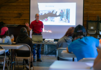 A Wyoming Game and Fish Department game warden delivers a presentation to a group of students.