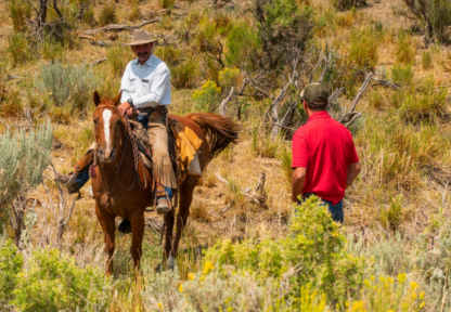 A Game and Fish warden talks to a landowner on horseback