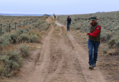 A Game and Fish employee works with volunteers to help update a fence to a wildlife-friendly design