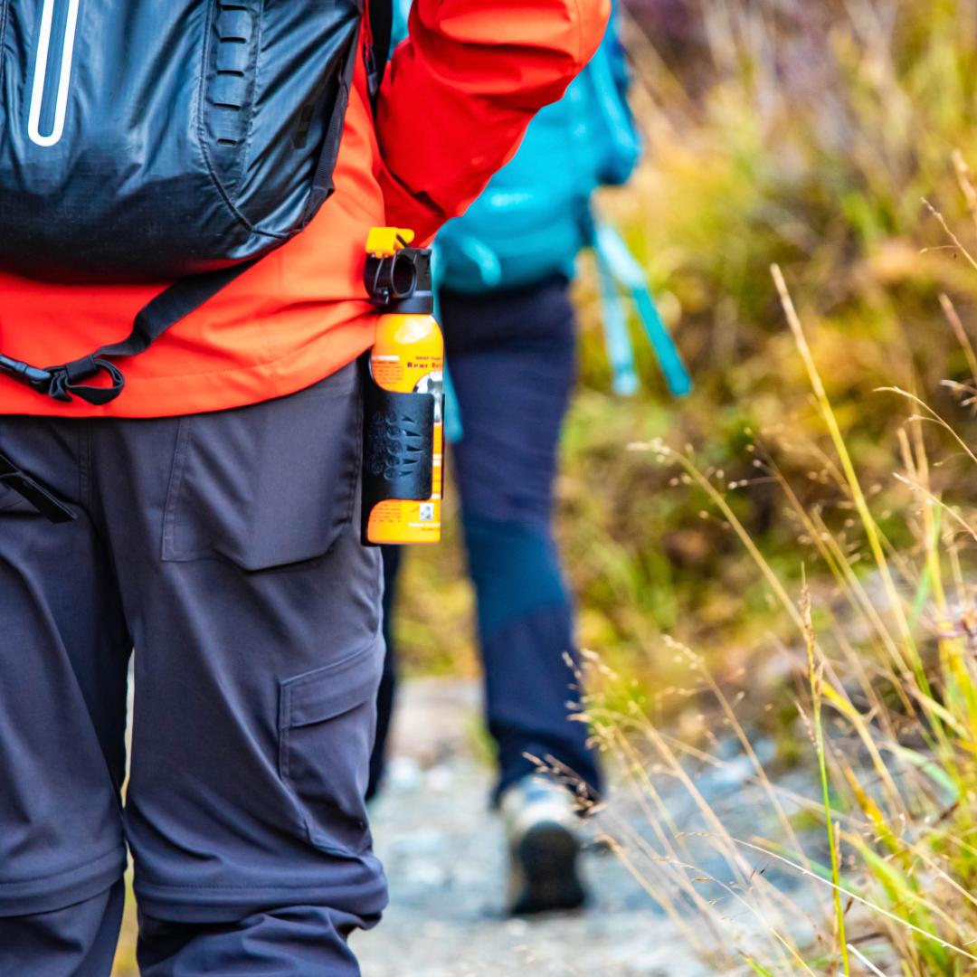 Bear spray self-defense attached to backpackers when hiking
