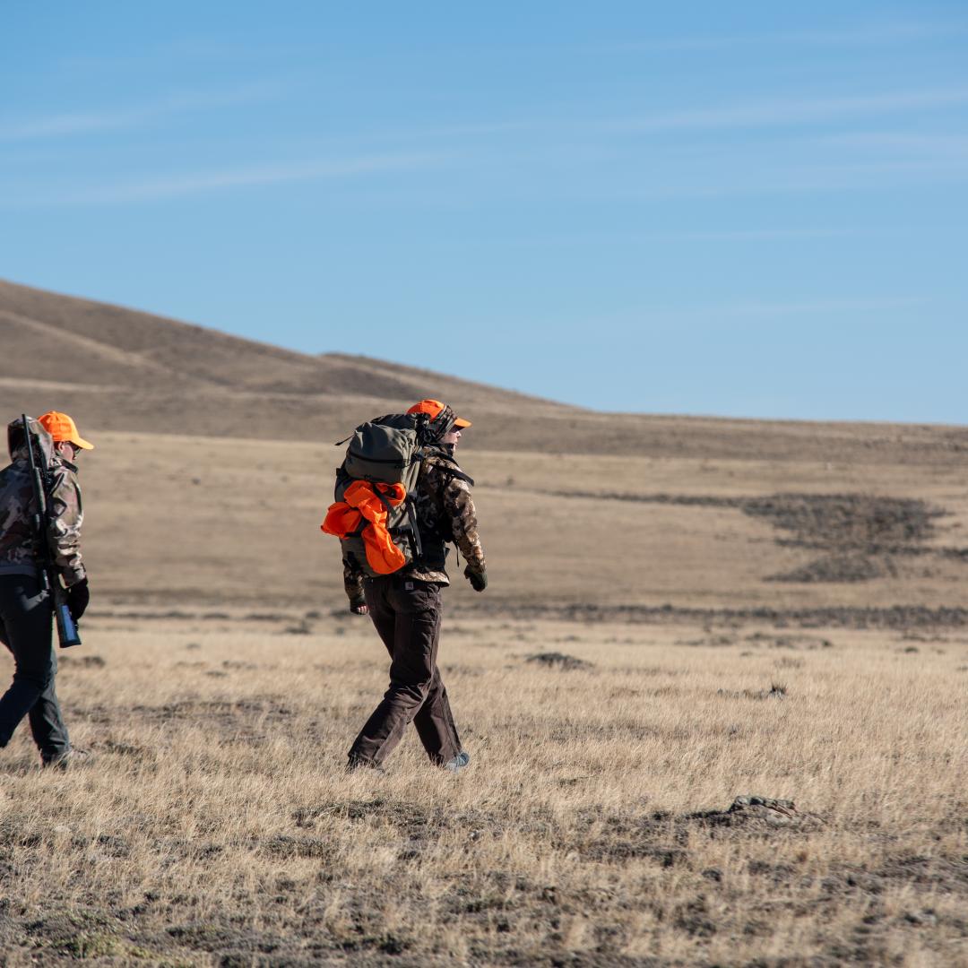 Hunters walking across landscape in Wyoming.