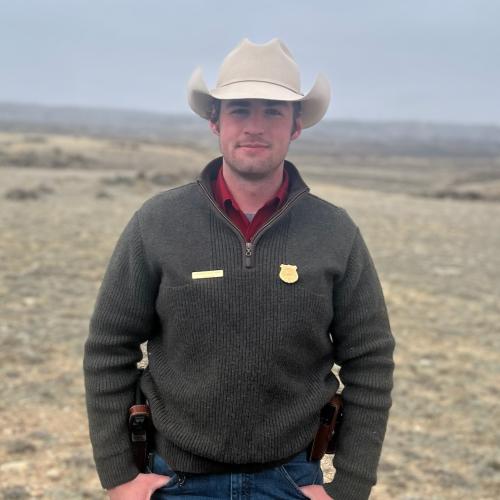 Worthen stands on an open sagebrush hillside