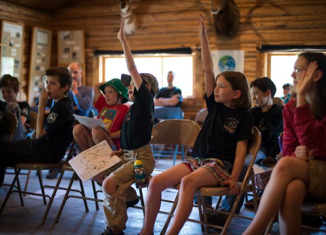Youth at Whiskey Mountain Conservation Camp Youth in a classroom setting raising their hands