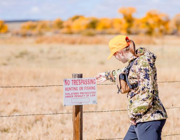 Hunter reading "no trespassing" sign