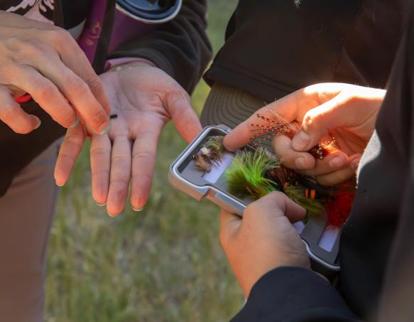 Two Wyoming Game and Fish employees clean concrete raceways outside at Clark's Fork Fish Hatchery.