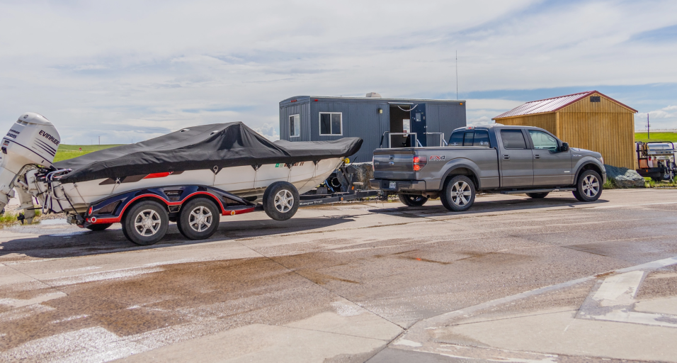 Pickup truck with a motorized watercraft stopped at an AIS check station