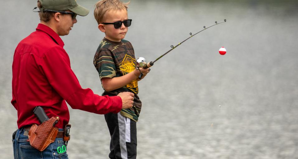 Child fishing with game warden