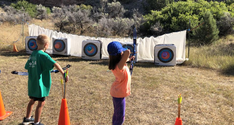 Participants of Medicine Lodge Kids Outdoor Day practice archery 