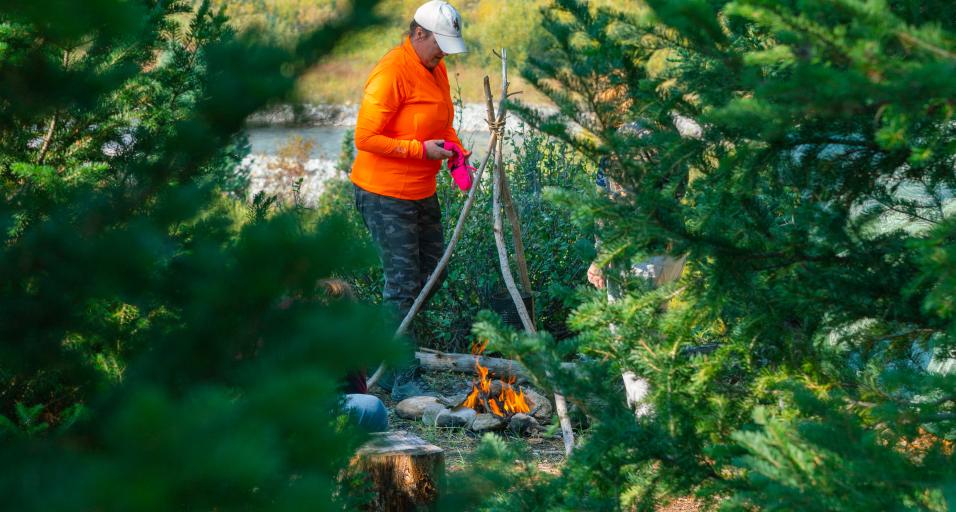Woman hunter tending to a fire