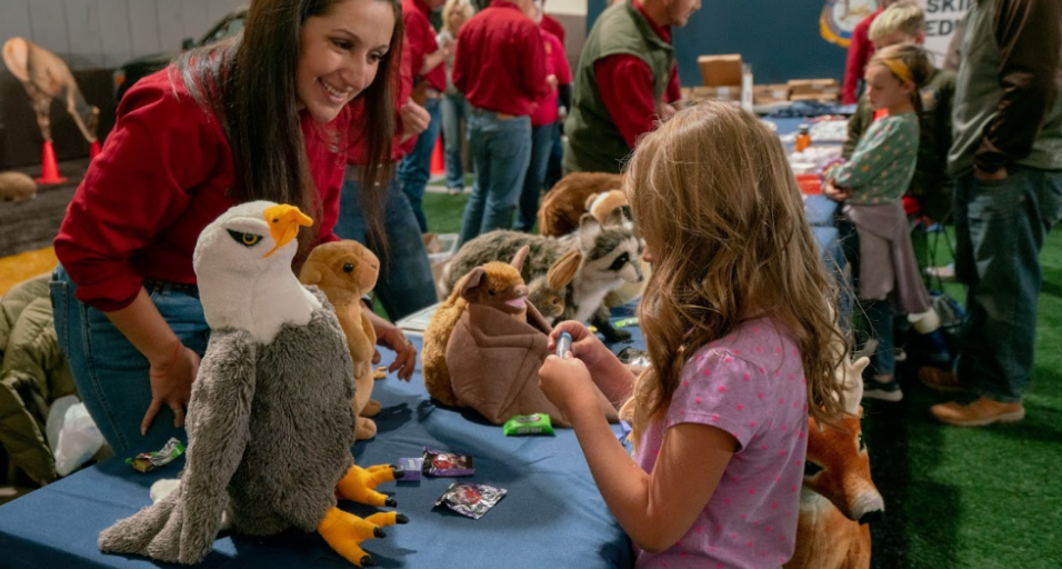 Kids interacting with Game and Fish employee at UW game