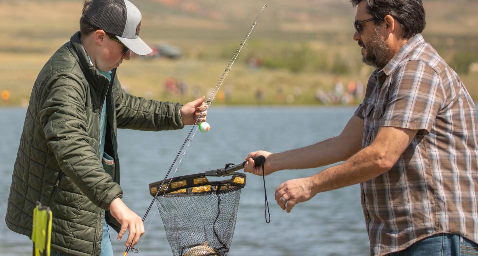 Two anglers reel in a fish
