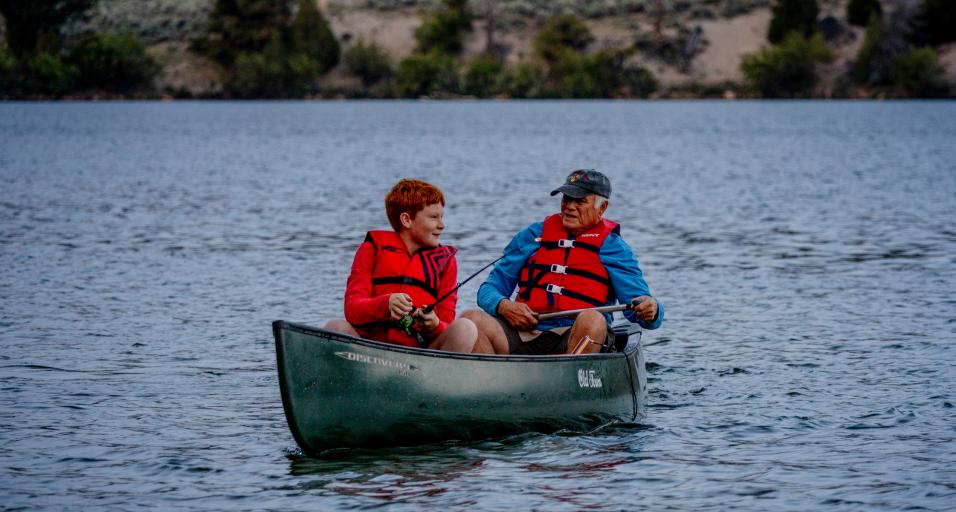 Instructor taking youth camp attendee out to fish during a Game and Fish Summer Camp in 2024.