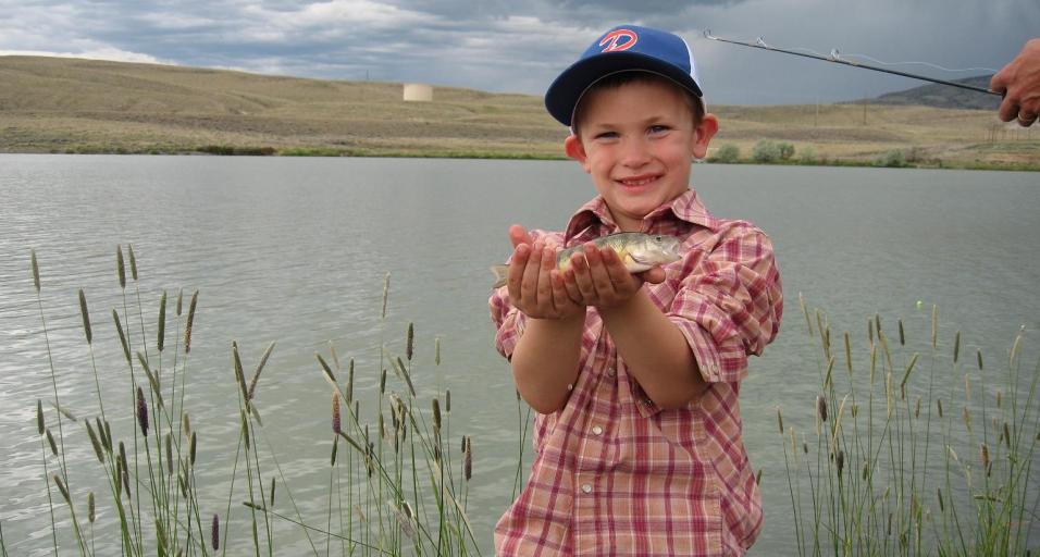 A child shows off is fish caught at a Kids Fishing Day event in Cody at New Cody Reservoir. 