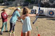 Participants of the 2024 Medicine Lodge Kids Outdoor Day practice archery 