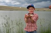 A child shows off is fish caught at a Kids Fishing Day event in Cody at New Cody Reservoir. 
