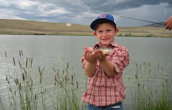 A child shows off is fish caught at a Kids Fishing Day event in Cody at New Cody Reservoir. 