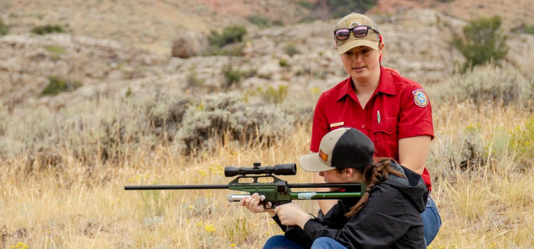 Game and Fish employee teaching how to use a dart gun