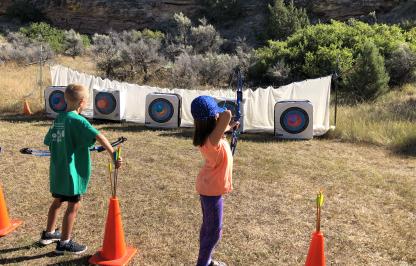 Participants of Medicine Lodge Kids Outdoor Day practice archery 