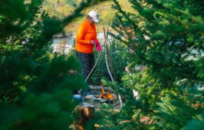 Woman hunter tending to a fire