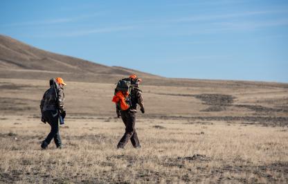Hunters walking across landscape in Wyoming. Hunters walking across landscape in Wyoming.
