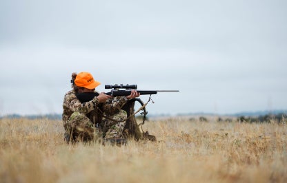 Woman hunting with rifle in blaze orange