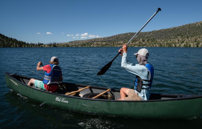 Boys canoeing, wearing life jackets
