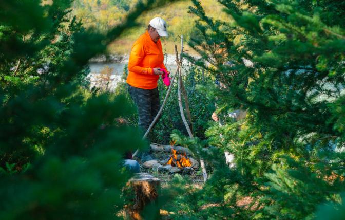 Woman hunter tending to a fire