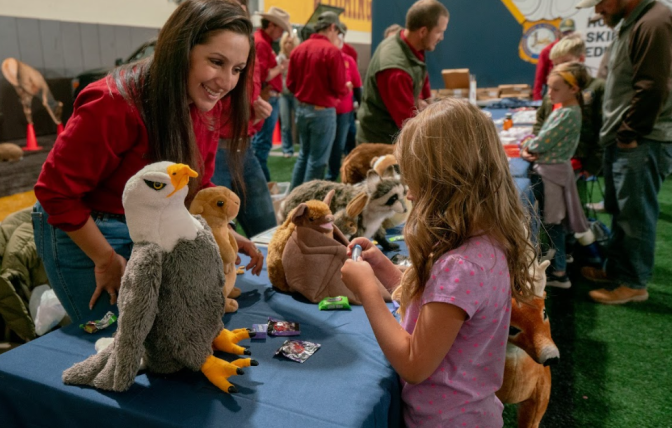 Kids interacting with Game and Fish employee at UW game