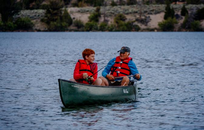 Instructor taking youth camp attendee out to fish during a Game and Fish Summer Camp in 2024.