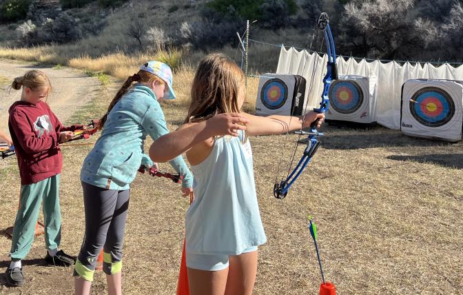 Participants of the 2024 Medicine Lodge Kids Outdoor Day practice archery 
