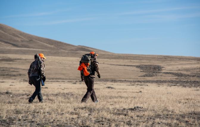 Hunters walking across landscape in Wyoming.