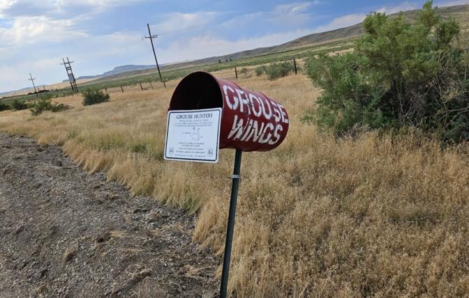 A red metal wing barrel on a t-post along a road