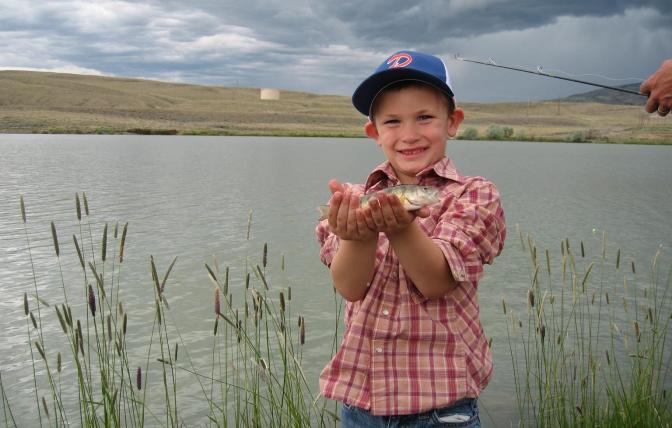A child shows off is fish caught at a Kids Fishing Day event in Cody at New Cody Reservoir. 