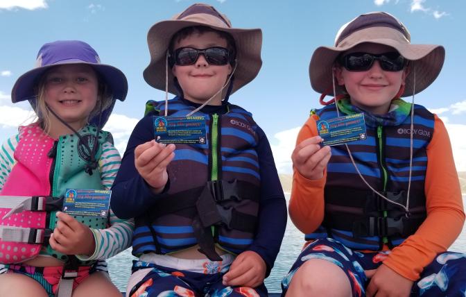 kids on a boat in lifejackets